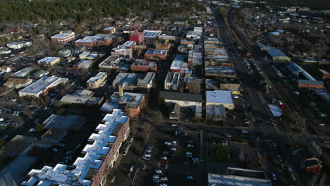 Drohnenaufnahme-Der-Gebäude-In-Der-Innenstadt-Von-Flagstaff,-AZ,-USA-Und-Des-Straßenverkehrs-An-Einem-Sonnigen-Wintertag