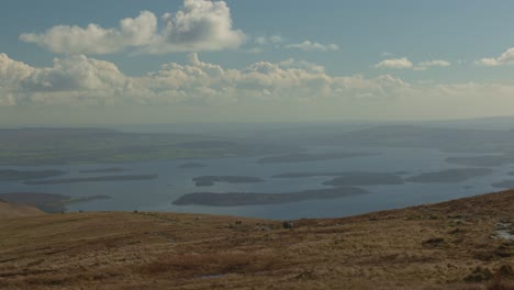 Hand-held-shot-of-hikers-heading-back-down-from-Ben-Lomond-towards-Loch-Lomond