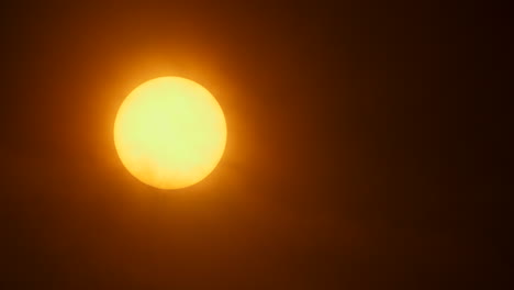 Close-up-of-the-sun-with-thin-hazy-clouds-moving-in-front