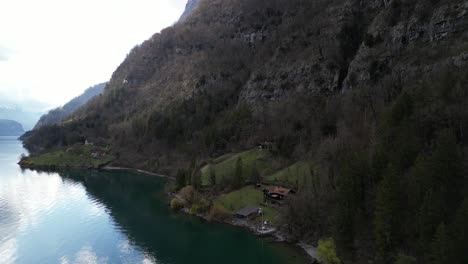 Clip-Panorámico-De-Drones-Que-Muestra-Una-Remota-Cabaña-De-Madera-Junto-A-Un-Lago,-Perfecta-Para-Unas-Vacaciones-De-Senderismo,-En-Las-Montañas-Alpinas-Suizas