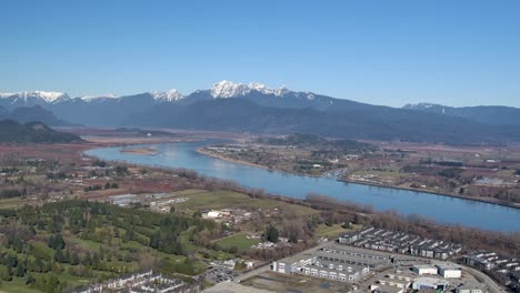 Vista-Aérea-Del-Paisaje-Fluvial-Con-Fondo-De-Montaña---Día-Soleado