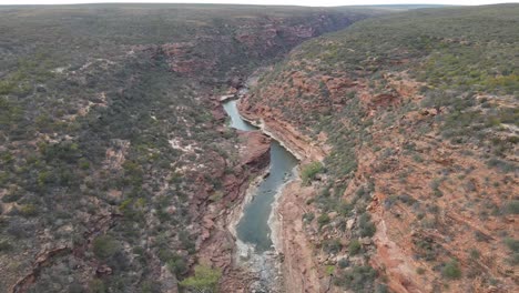 Antena-De-Drones-Moviéndose-Hacia-Atrás-Sobre-Un-Desfiladero-Australiano-Y-Un-Parque-Nacional-Con-Un-Río-Que-Fluye-En-Un-Día-Soleado