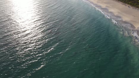 Drone-aerial-moving-forward-and-panning-up-over-a-pretty-beach-with-white-sand-in-Western-Australia