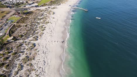 Drone-aerial-over-a-pristine-coastal-town-with-a-beautiful-beach