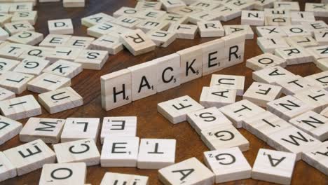 Detailansicht:-Scrabble-Spiel-Buchstabensteine-Bilden-Wort-Hacker-Auf-Dem-Tisch