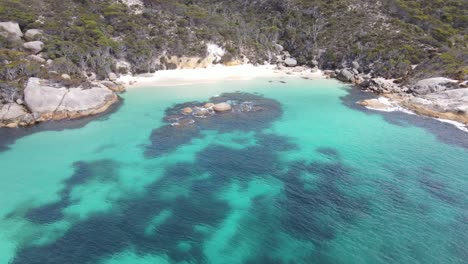 Drone-aerial-showing-blue-water-beach-over-a-coastal-area-in-Australia