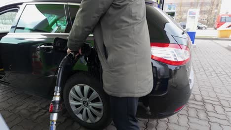 Shot-of-a-man-filling-fuel-to-his-black-Peugeot-car-in-the-petrol-station