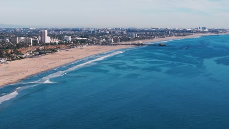 Disparo-Aéreo-De-Drones-De-Gran-Elevación-Volando-Hacia-Atrás-Con-Vistas-A-La-Playa-De-Santa-Mónica