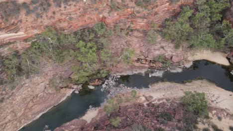 Drone-aerial-panning-right-over-an-Australian-gorge-and-national-park-with-a-river-flowing-on-a-sunny-day