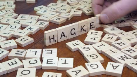 Word-HACKED-made-by-putting-Scrabble-tiles-on-edge-on-wooden-table