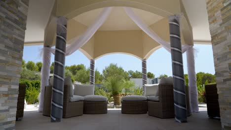 Slow-motion-shot-of-an-exterior-wedding-canopy-with-white-curtains-hanging