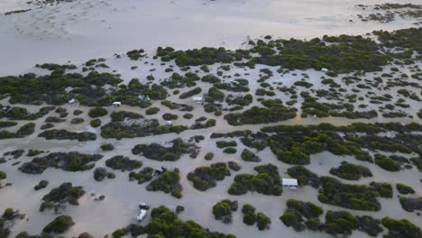 Drohnen-Luftaufnahme-über-Einem-Campingplatz-Am-Strand-Mit-Windmühlen-Bei-Sonnenaufgang