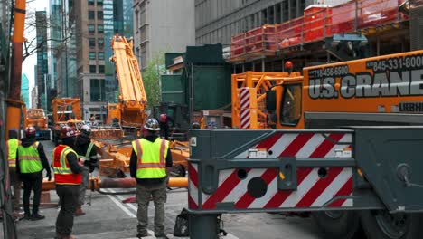 Una-Toma-Estacionaria-De-Hombres-En-La-Calle-En-Un-Sitio-De-Construcción-En-La-Ciudad-De-Nueva-York-En-Un-Día-Nublado