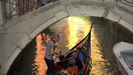 Gondolero-Con-Góndola-Navega-Por-Un-Par-De-Turistas-En-Uno-De-Los-Muchos-Canales-De-Agua-En-Venecia-En-Un-Cálido-Día-De-Primavera