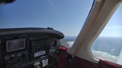 Plane-Overflying-Beautiful-Beach-on-a-Sunny-Day,-View-from-Cockpit