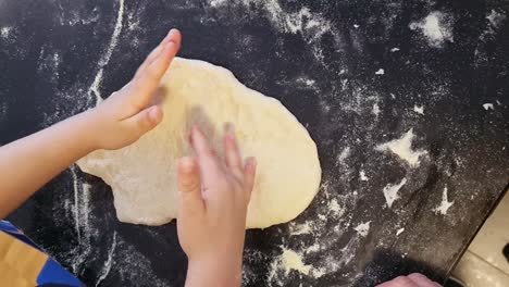 A-boy-stretching-the-pizza-dough-by-hand