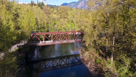 Beautiful-scenic-aerial-view-of-bridge-crossing-over-Snoqualmie-Middle-Fork-River-in-North-Bend,-Washington-State