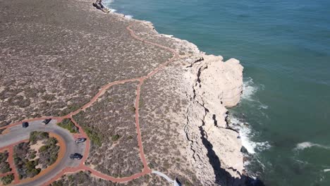 Drone-aerial-pan-down-over-natural-bridge-and-castle-rock-in-Kalbarri