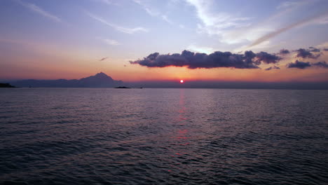 Amanecer-Sobre-El-Mar-Egeo-Y-La-Costa-De-La-Isla-Griega,-Volando-Bajo-Sobre-El-Agua,-Disparo-De-Drones