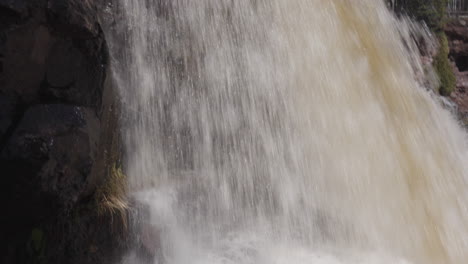 -Close-Up-of-Rushing-Waterfall-on-Rocky-Cliff
