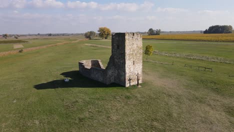 Aerial-parallax-around-ancient-stone-truncated-tower-in-Soltszentimre,-Hungary