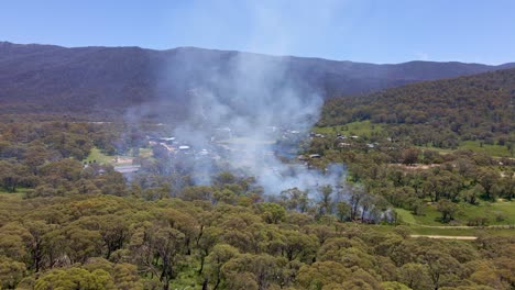Drone-shot-of-smoke-getting-out-of-something-burning-in-forest-of-Crackenback,-New-South-Wales,Australkia