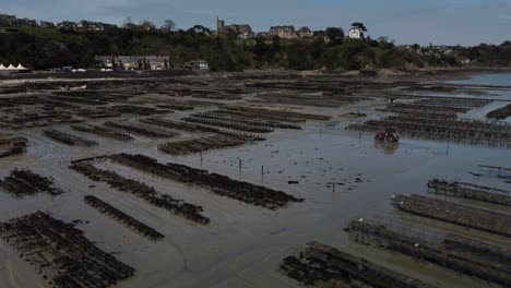 Aerial-4K-Drone-footage-of-a-large-oyster-farm,-Terrain-de-culture-d‘huîtres,-on-the-beach-of-Cancele,-Brittany,-France