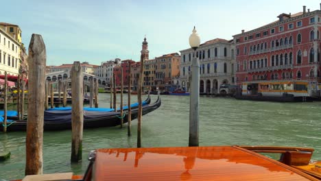 Un-Hombre-Italiano-Navega-Desde-Su-Lugar-De-Estacionamiento-En-El-Gran-Canal-De-Venecia-Con-Su-Lancha-Rápida-De-Madera.