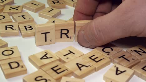 Among-Scrabble-tiles,-letters-form-word-TRASH-on-closeup-white-desktop