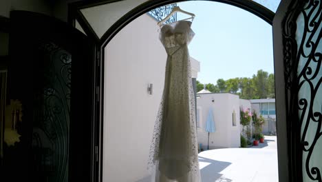 Wedding-dress-hanging-in-ornate-entryway