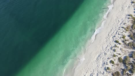 Drone-aerial-over-a-pristine-beach-showing-a-clear-line-in-the-water