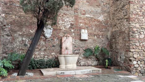 Fuente-De-Agua-Junto-A-Las-Murallas-De-La-Alcazaba-Con-Una-Cruz-Málaga-España