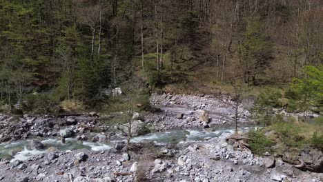 Drone-Vuela-Junto-Al-Río-Con-Agua-Cristalina-Con-Fogata-En-Una-Pequeña-Isla-Al-Lado-En-Austria,-Europa