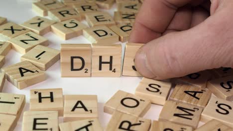 Three-Scrabble-letter-tiles-form-US-Govt-agency-acronym-DHS-on-table