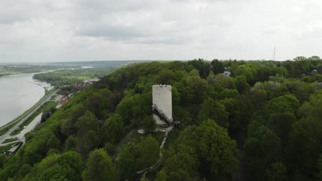 Aerial-Drone-Fly-Forested-Green-Area,-White-Castle-Tower-Building-in-Poland-Trees-around-Vistula-river-bay-area,-Kazimierz-Dolny-Town