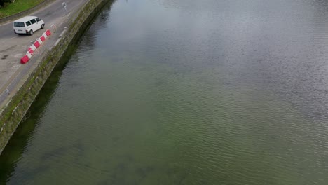 White-Van-driving-on-Lagoa-das-Sete-Cidades-bridge,-Azores,-Portugal