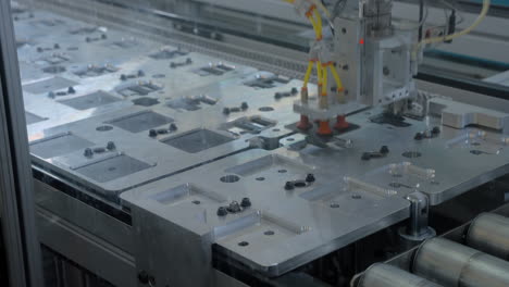 Zeitraffer-Von-Roboterarmen,-Die-Teile-Aus-Behältern-Auf-Einem-Automatisierten-Förderband-Aufnehmen