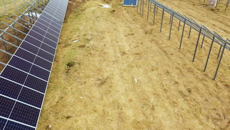 Aerial-view:-Installing-process-of-solar-panels-on-large-farm-field-in-nature