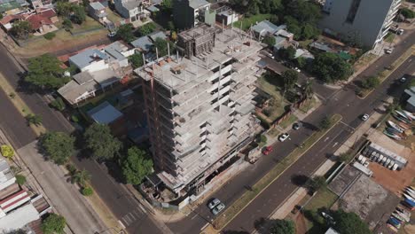 Dynamic-drone-footage-showcases-the-construction-progress-of-riverside-buildings,-capturing-the-blend-of-urban-development-and-natural-beauty