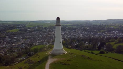 Aerial-dolly-zoom-shot-of-the-Sir-John-Barrow-Monument,-creating-a-dramatic-vertigo-effect-as-the-landscape-stretches-away