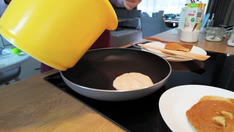 Close-up-shot-of-a-woman-preparing-pancakes-in-the-kitchen-at-home-in-the-morning-for-breakfast