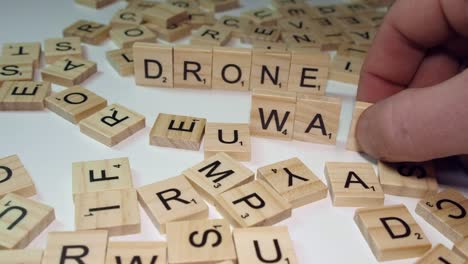 Narrow-focus-close-up-Scrabble-tile-letters-make-words-DRONE-and-WAR