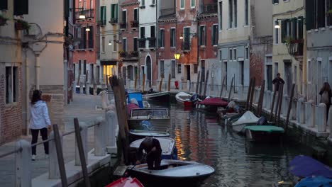 Alter-Italiener-Reinigt-Sein-Boot,-Das-Im-Wasserkanal-In-Venedig-Geparkt-Ist