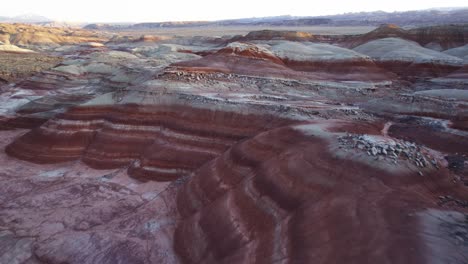 Aerial-4k-drone-low-elevation-view-of-Bentonite-Hills,-Utah,-at-blue-hour-colorful-mars-like-landscape-appear-as-softly-contoured,-banded-hills-in-varying-hues-of-brown,-red,-purple,-gray,-and-green