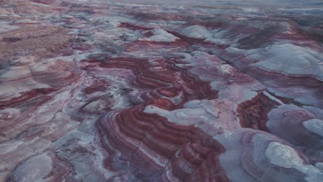 Aerial-4k-drone-flyover-view-of-Bentonite-Hills,-Utah,-at-blue-hour-colorful-mars-like-landscape-appear-as-softly-contoured,-banded-hills-in-varying-hues-of-brown,-red,-purple,-gray,-and-green