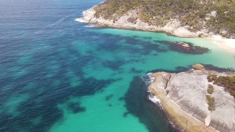 Antena-De-Drones-Moviéndose-Hacia-Una-Playa-Aislada-Con-Agua-Azul-Brillante-En-Australia