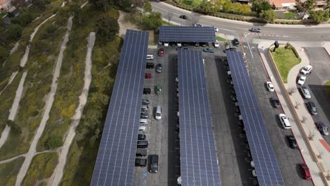 Solar-panels-provide-clean-energy-and-shade-for-a-covered-parking-lot---aerial-tilt-down