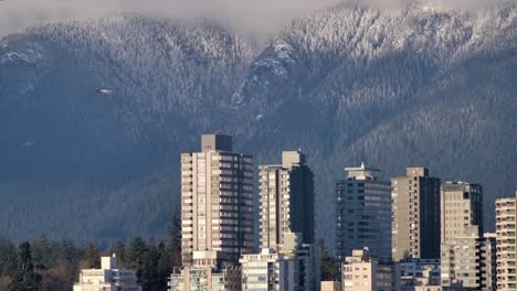 Flugzeug-Fliegt-über-Küstenstadtlandschaft-Und-Winterwaldberge-In-Vancouver,-British-Columbia,-Kanada