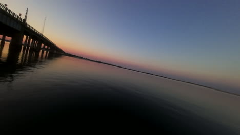 Tejido-FPV-Entre-Soportes-De-Puentes-Al-Atardecer-Sobre-La-Bahía-De-Nueva-Jersey