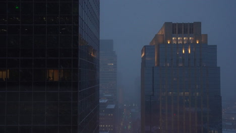 Static-establishing-shot-of-tall-building-in-a-city-during-snow-storm